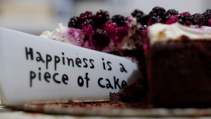 Cake with text ‘Happiness is a piece of cake’ inserted.