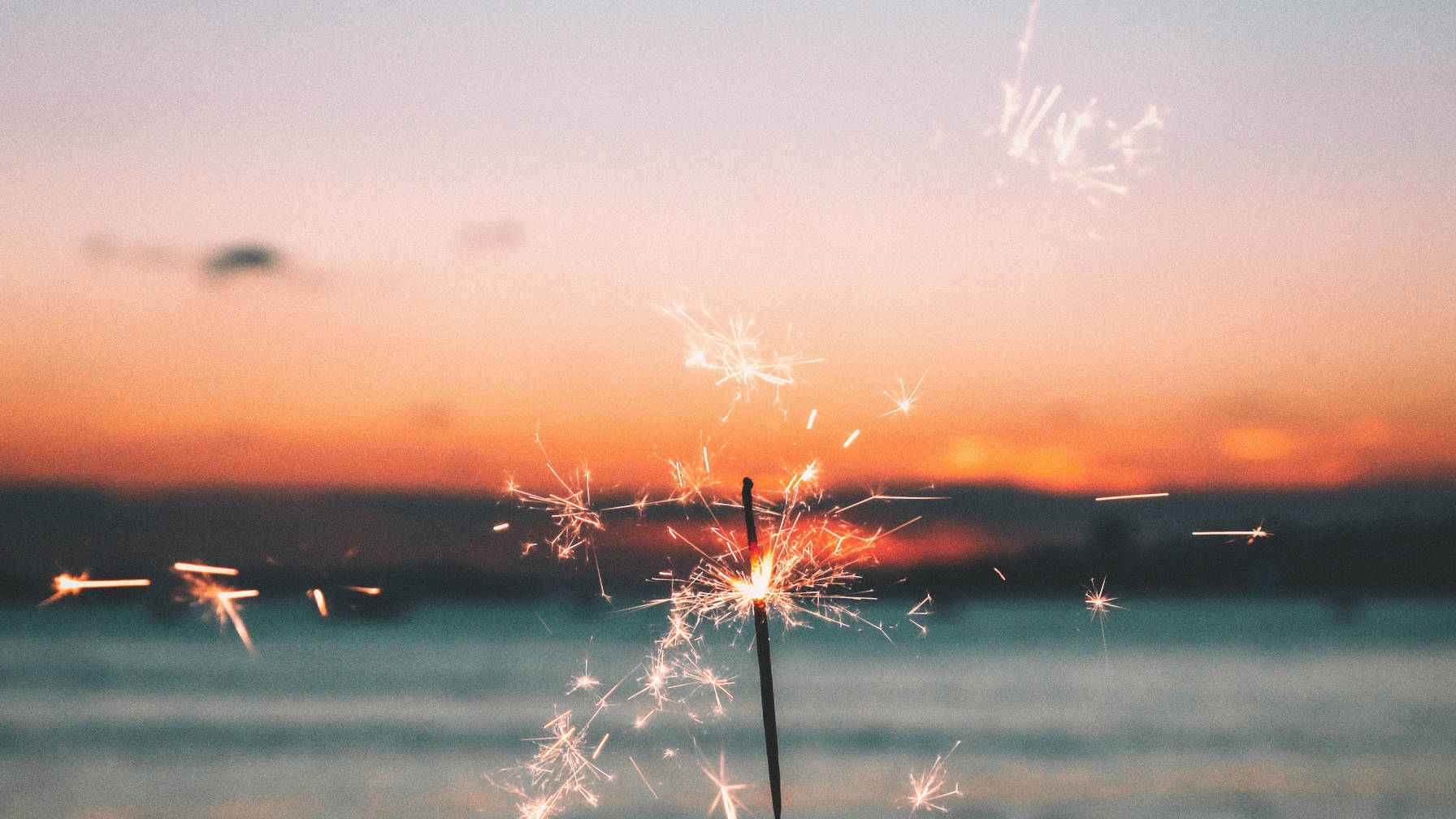 Sparkler firework with a background of sunset.