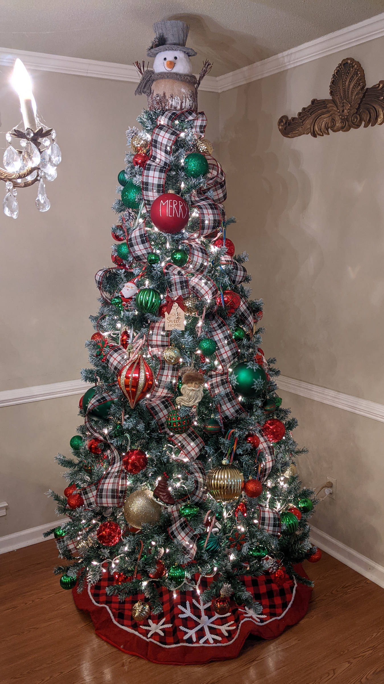 Fully decorated Christmas tree with red, green, and gold ornaments.