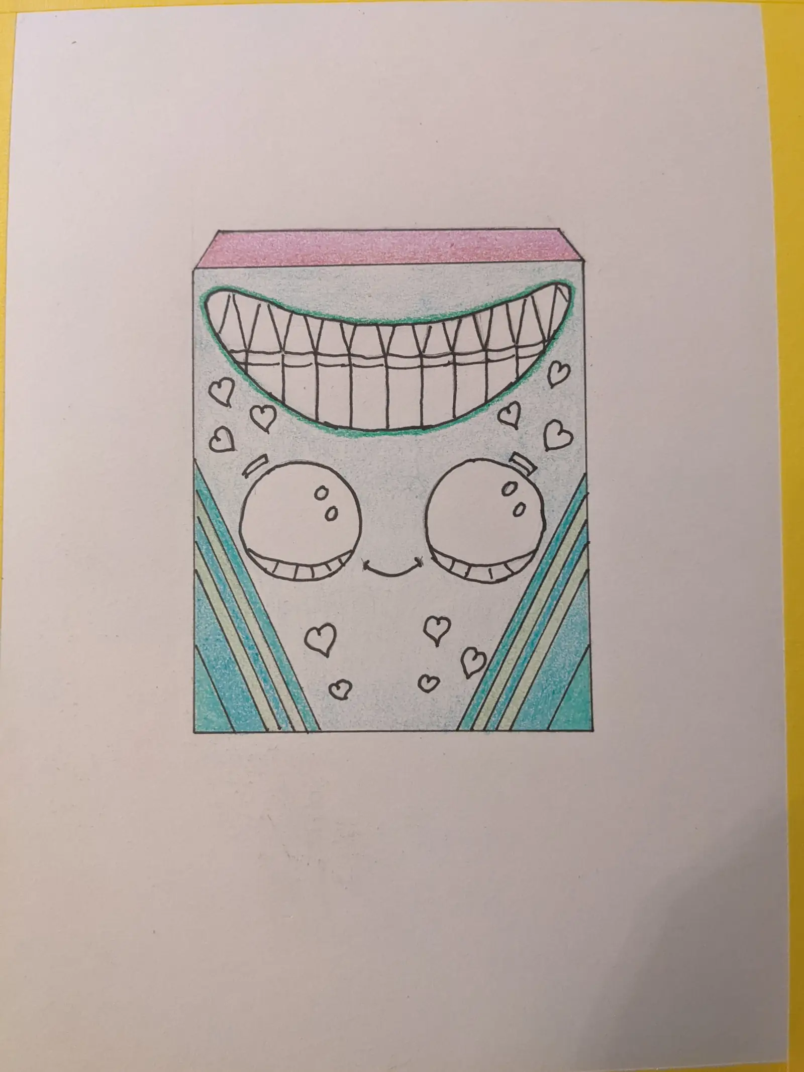 Hand-drawn color crayon box with a face and hearts on the design. Partially colored.