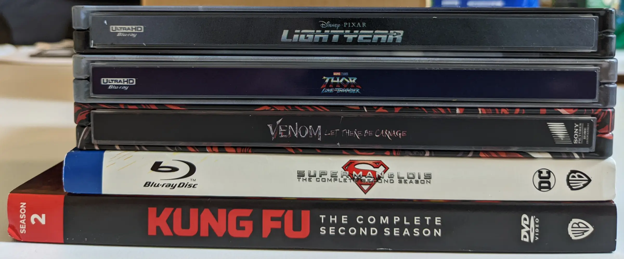 Stacked set of Blu-ray and DVD movies and television season sets.