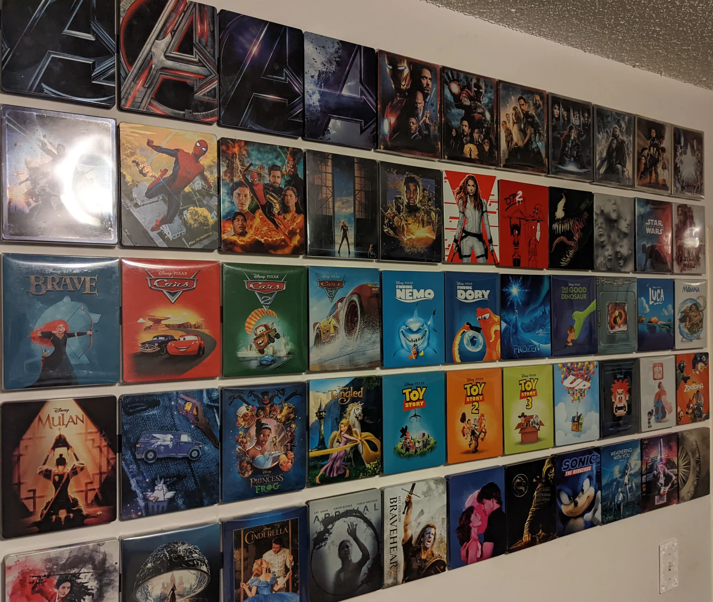 Five rows of steelbook movie cases attached to a wall.