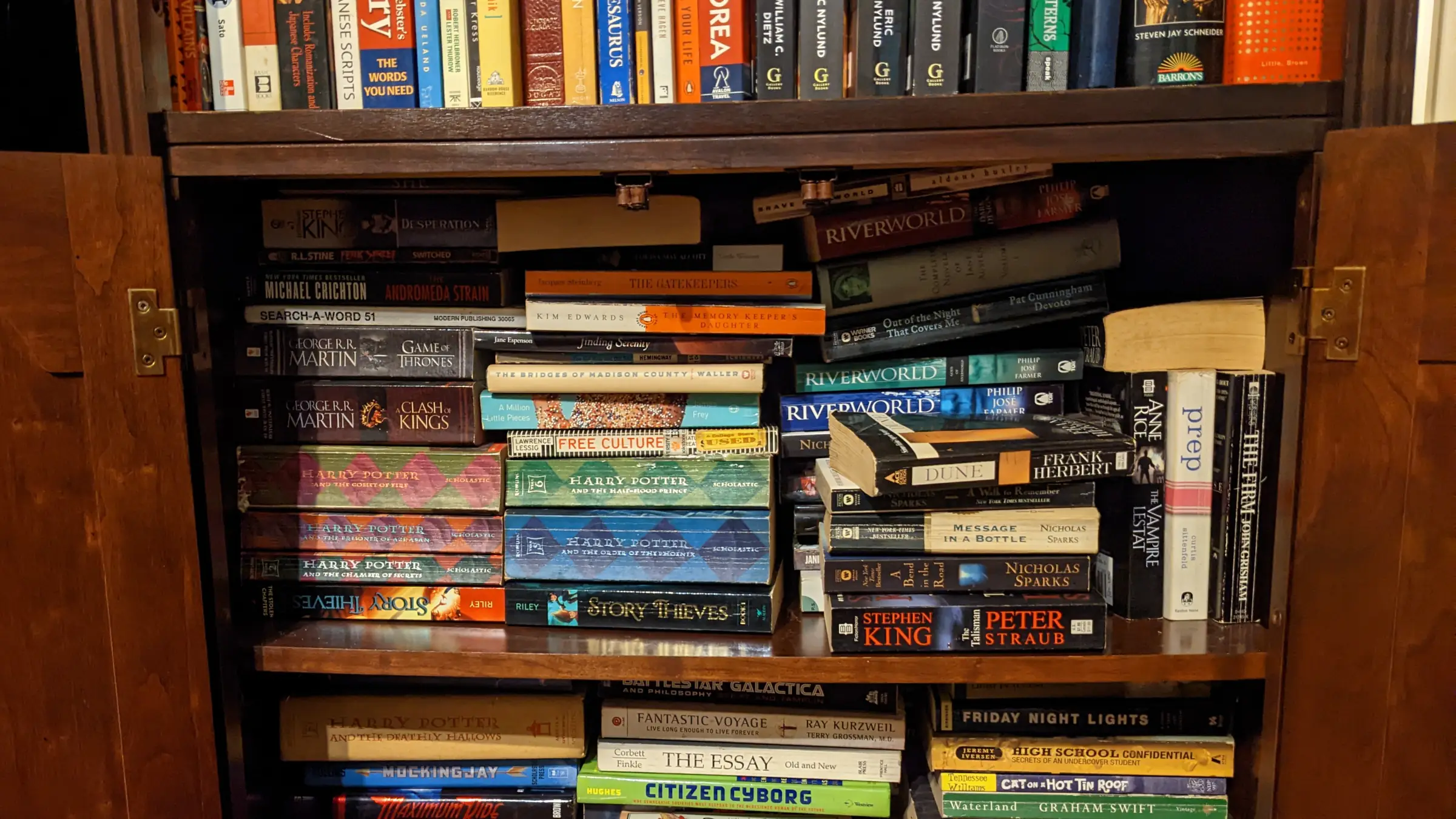 Part of a bookshelf with a variety of books stacked on it.