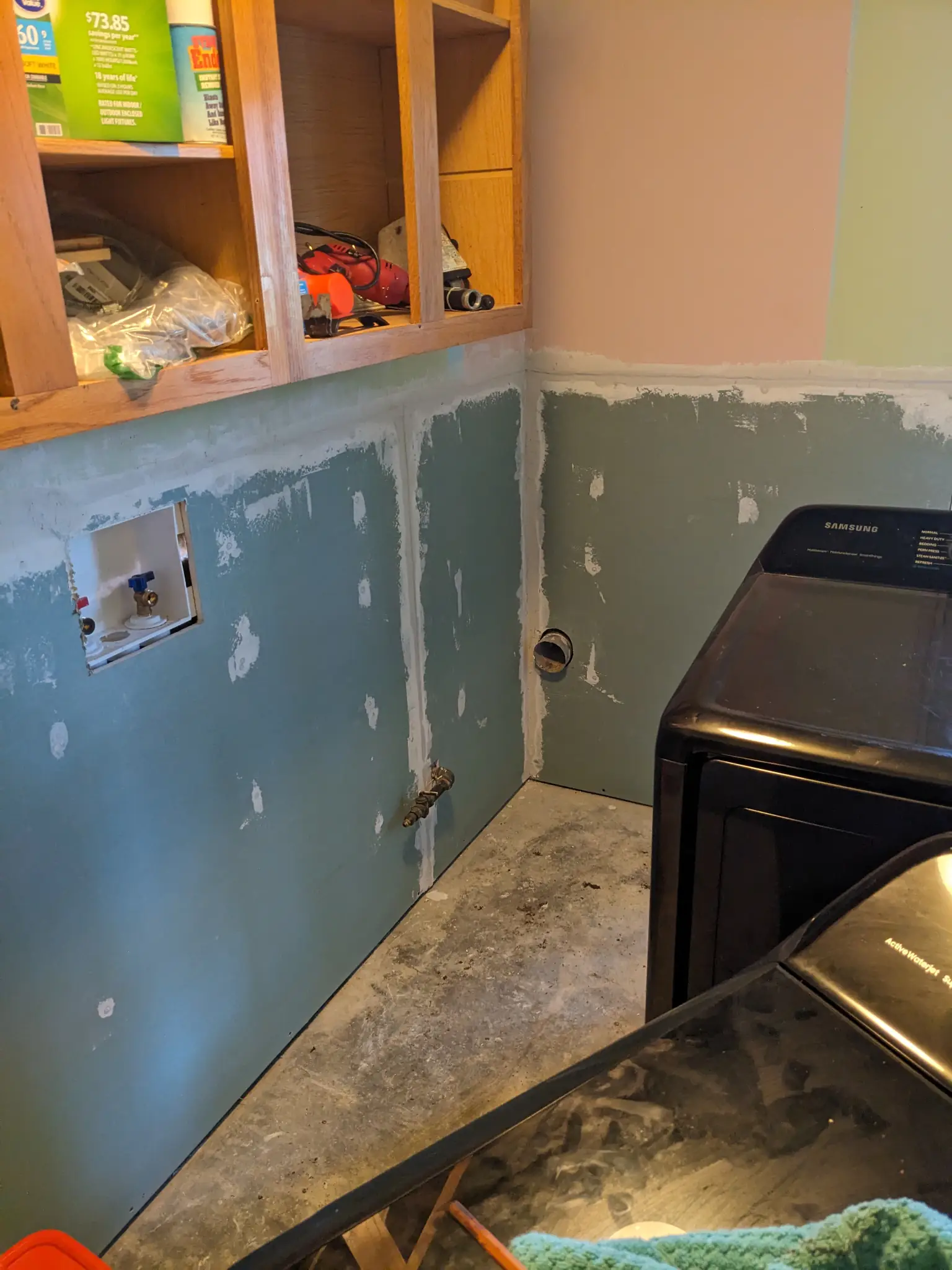 Laundry room with new sheetrock walls.