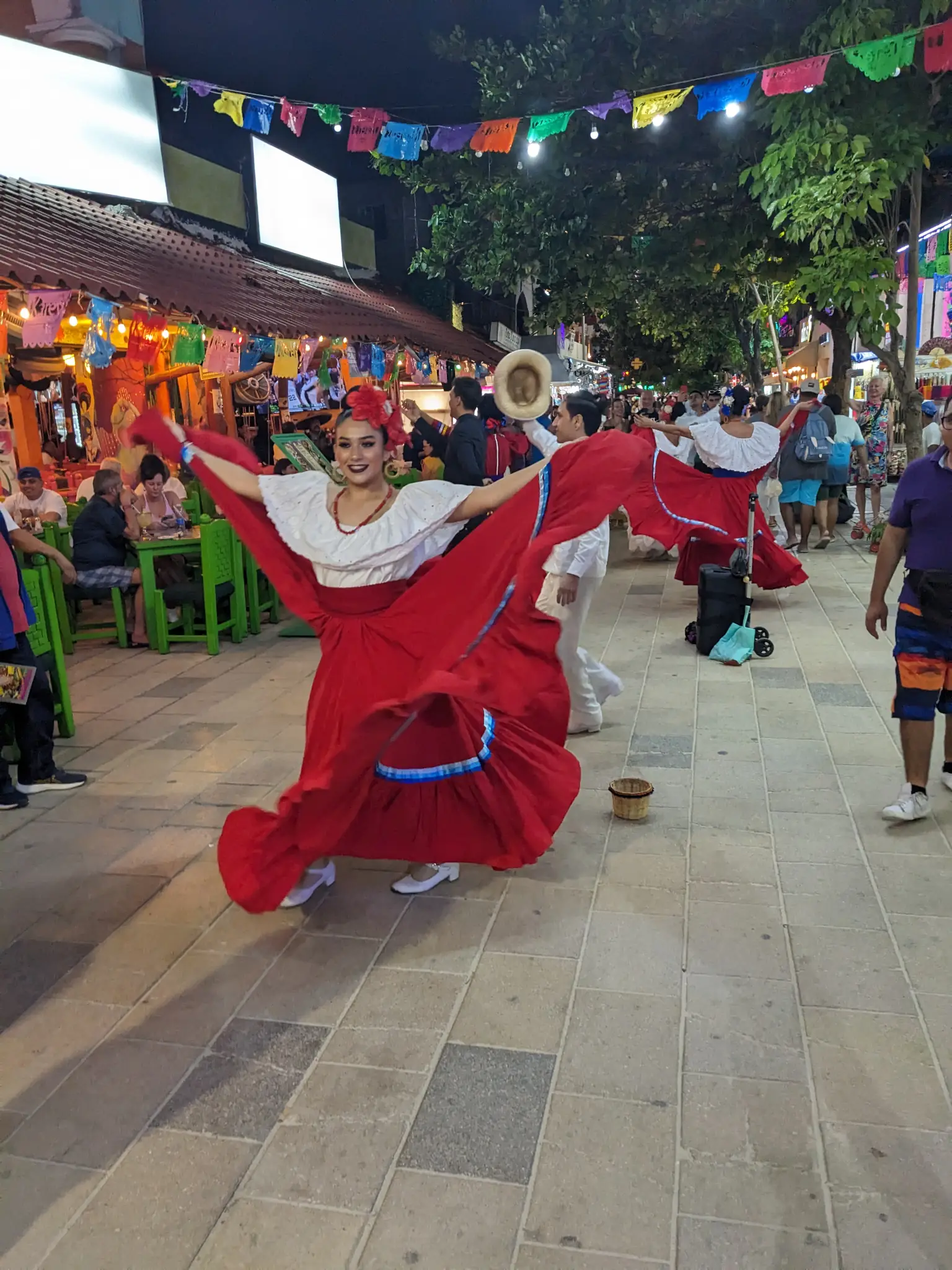 Street performers in red, dancing in the streets of Carmen del Play.