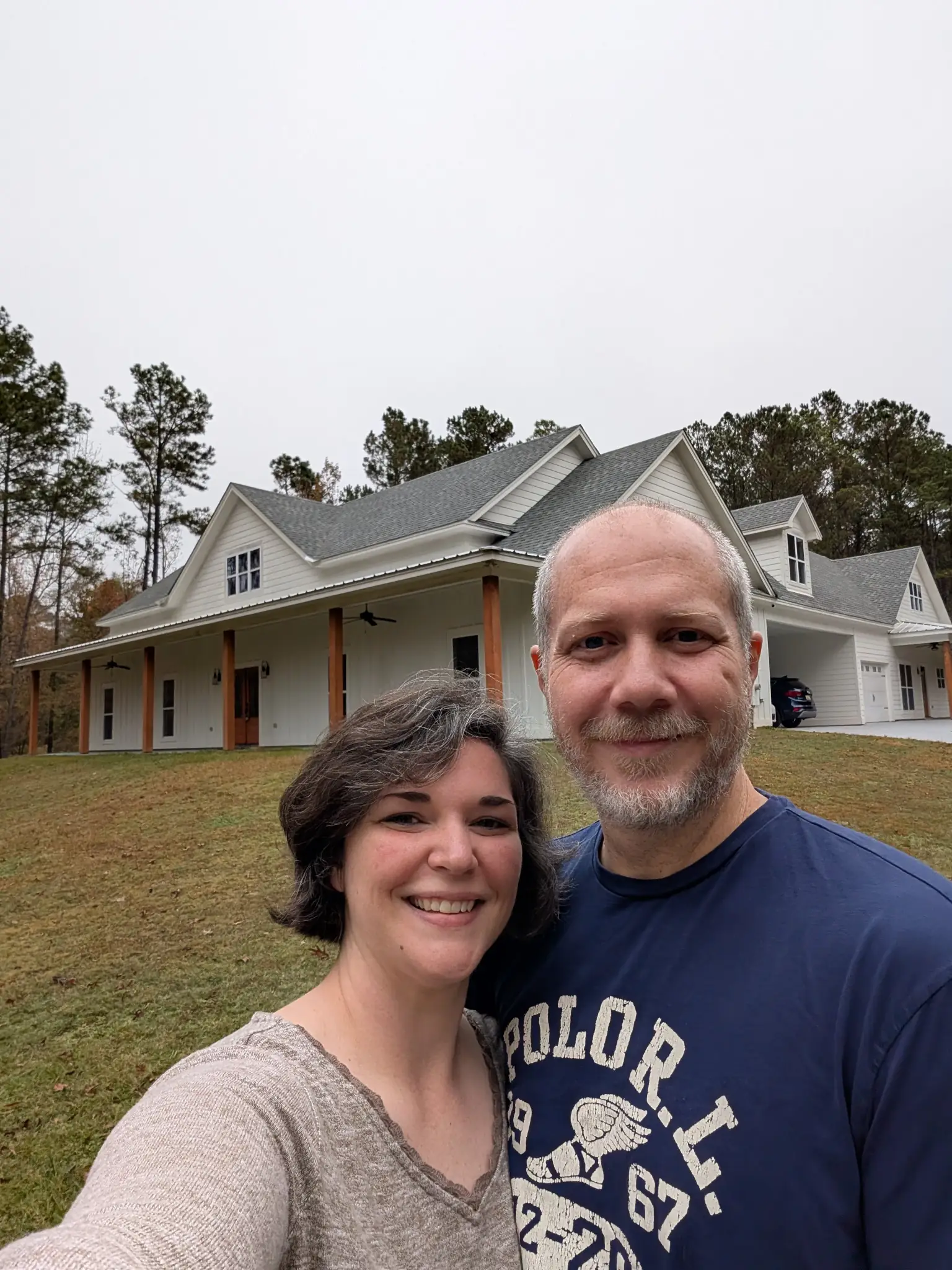Ashley and Justin standing in front of a house.