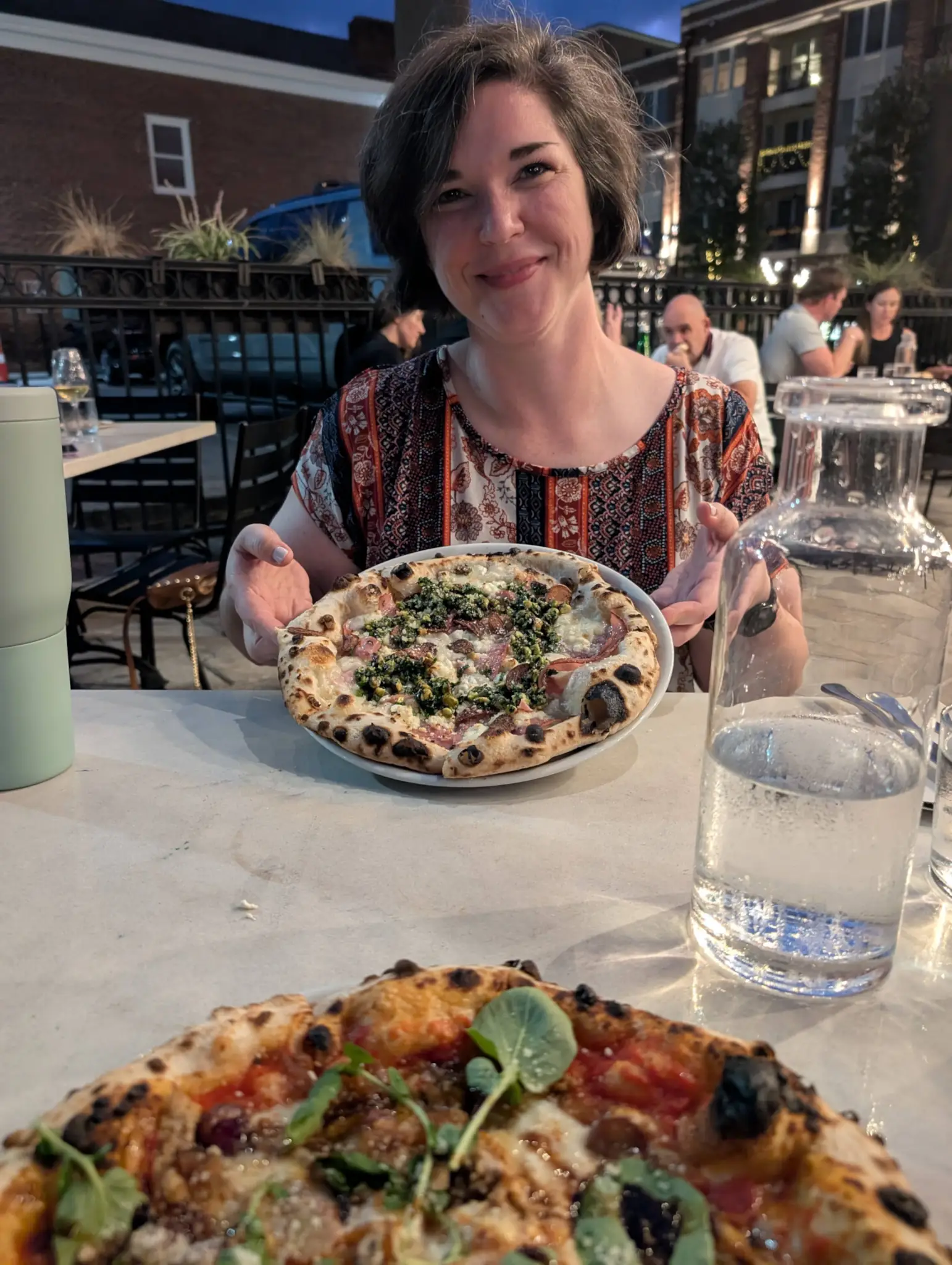 Ashley showing her pizza at an Italian restaurant.